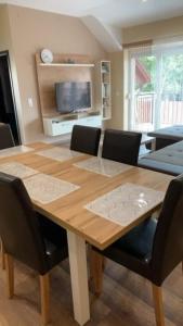 a dining room with a wooden table and chairs at Felüdülő Apartman Balatonlelle in Balatonlelle