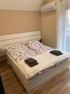a bedroom with a bed with two towels on it at Felüdülő Apartman Balatonlelle in Balatonlelle
