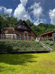 a house with a colorful fence in front of it at Sielski Domek Ręboszewo 94 in Ręboszewo