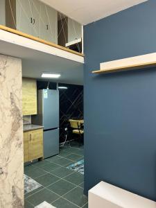 a kitchen with a blue wall and a refrigerator at Dua Apartament in Kashari