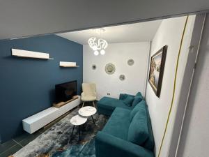 a living room with a blue couch and a tv at Dua Apartament in Kashari