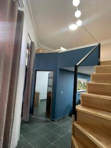 a room with stairs and a blue wall at Dua Apartament in Kashari +1 photo