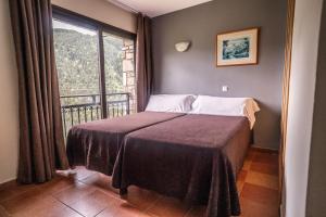 a bedroom with a bed with a large window at Hotel Ransol in El Tarter +45 photos