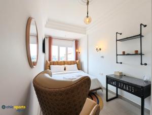 a bedroom with a bed and a chair and a mirror at Chic apart with a view in Yaoundé