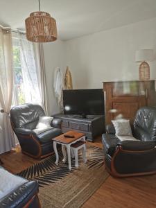 a living room with leather furniture and a coffee table at La douce Campagne in Flavigny-le-Grand-et-Beaurain
