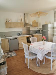 a kitchen with a table and chairs in a kitchen at La douce Campagne in Flavigny-le-Grand-et-Beaurain +3 photos