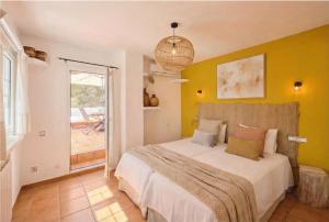 a bedroom with a bed with a yellow wall at Can Paredes Ibiza in Ibiza Town +45 photos