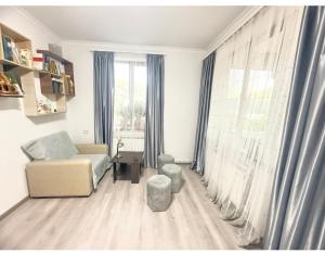 a living room with a couch and a chair and a window at Dilisharm in Dilijan