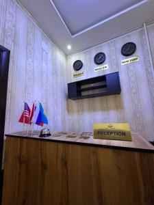 a reception desk with flags and plates on the wall at Uya Nest Osh in Osh +16 photos