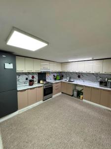 a large kitchen with white cabinets and a light at Uya Nest Osh in Osh