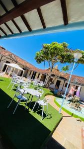 a group of white tables and chairs on the grass at Casa de ejercicios zaxue colonial in Zapatoca