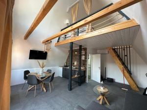 a living room with a staircase and a table and chairs at Laganini house Vinča in Belgrade