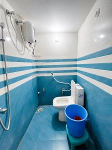 a blue and white bathroom with a toilet and a shower at Hotel Shreeji Palace - OPP Hanuman Garhi Mandir in Ayodhya