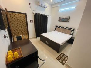a small room with a bed and a table at Govind Atithi grah in Ayodhya