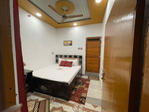 a small bedroom with a bed and a ceiling at Govind Atithi grah in Ayodhya