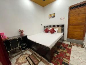 a small bedroom with a bed and a chair at Govind Atithi grah in Ayodhya