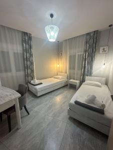 a bedroom with two beds and a table and a lamp at Amela House in Skala Kallirachis