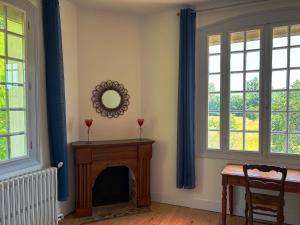 a living room with a fireplace and two windows at Chambre spacieuse in Pineuilh +1 photo