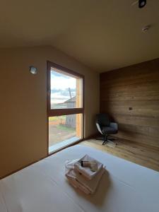 a bedroom with a bed with a window and a chair at Vila Mill in Sveti Jurij ob Ščavnici