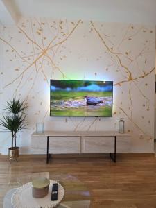 a living room with a flat screen tv on a wall at Gold Apartman in Pančevo