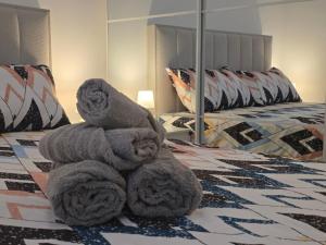 a pile of towels sitting on top of a bed at Gold Apartman in Pančevo