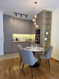 a kitchen and dining room with a table and chairs at Gold Apartman in Pančevo