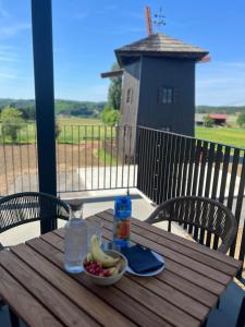 a wooden table with a bowl of fruit and a drink at Vila Mill in Sveti Jurij ob Ščavnici
