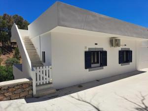 a white house with a staircase and windows at Vromolithos View House in Vromolithos