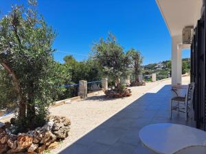 a patio with a table and chairs and trees at Vromolithos View House in Vromolithos +52 photos