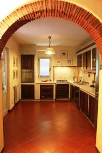 a large kitchen with an archway in the middle at La Cascina nel Roseto in Rigutino