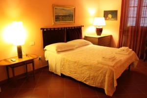 a bedroom with a bed and two lamps on tables at La Cascina nel Roseto in Rigutino +29 photos