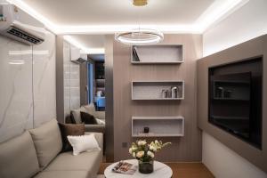 a living room with a couch and a tv at Stylish Pool View 1BDR Apartment Bang Tao in Ban Thalat Choeng Thale