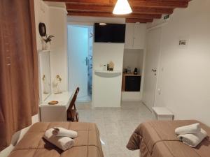 two beds in a room with a kitchen and a bathroom at MMrooms Μονά κρεβάτια 2ος όροφος in Tinos