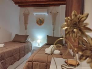 a bedroom with two beds and a table with a mirror at MMrooms Μονά κρεβάτια 2ος όροφος in Tinos