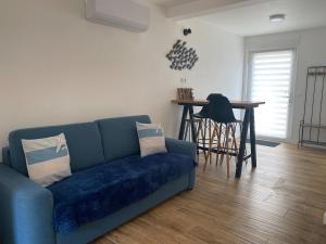 a living room with a blue couch and a table at La Cabane Marine in Sangatte +4 photos