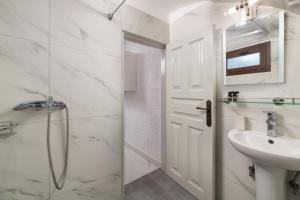 a white bathroom with a shower and a sink at Casa Tradizionale in Rhodes Town +17 photos