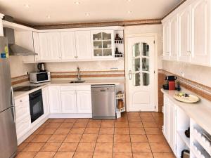 a kitchen with white cabinets and a tile floor at Can Paredes Ibiza in Ibiza Town