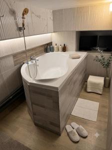 a bath tub in a bathroom with two slippers at Central Luxury Studio in Chişinău