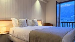 a bedroom with a large bed with a large window at Hôtellerie du Roy - Restaurant Chez Robin in Sainte-Hélène-sur-Isère +35 photos