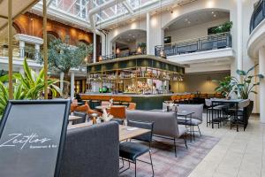a restaurant with tables and chairs and a bar at Hotel Alte Post Flensburg in Flensburg