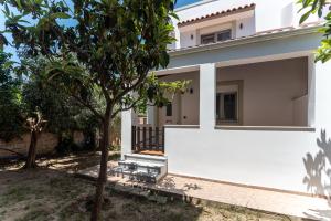 a white house with a tree in front of it at Gallery Home in Kardamaina
