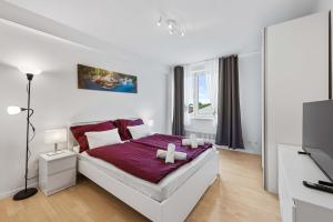 a white bedroom with a bed with a purple blanket at City Residence - Sankt Pölten in Sankt Pölten