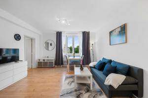 a living room with a blue couch and a table at City Residence - Sankt Pölten in Sankt Pölten