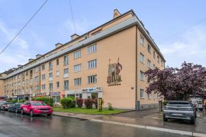 a large building with cars parked in front of it at City Residence - Sankt Pölten in Sankt Pölten
