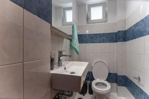 a bathroom with a toilet and a sink at Gallery Home in Kardamaina +13 photos