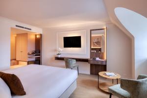 a hotel room with a bed and a tv at Golden Tulip Hotel de’ Medici in Bruges