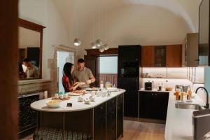 a man and a woman preparing food in a kitchen at Château du Pont d'Oye in Habay-la-Neuve