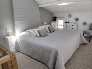 a white bedroom with a large bed with pillows at Gîte des Bujours in Saint-Bris-des-Bois +21 photos