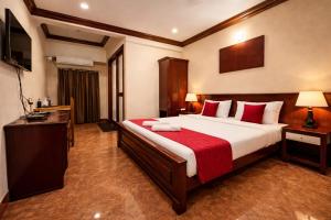 a bedroom with a large bed and a television at Klite stays - ZomoHotels in Pondicherry