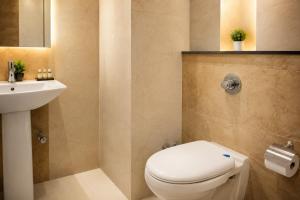 a bathroom with a toilet and a sink at Hotel The Mirage in Gil